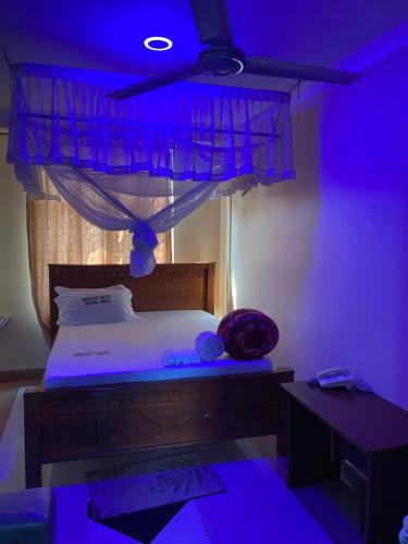 a bedroom with a bed with a blue lighting at New Gold city hotel in Mwanza