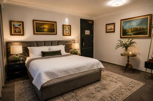 a bedroom with a large bed and paintings on the wall at The Square Hotel in Cluj-Napoca