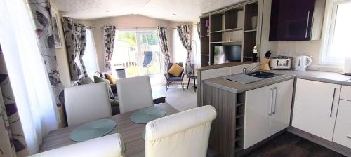 a kitchen and dining room with a table in a caravan at StaticCaravan-6Berth-DogFriendly in Northampton