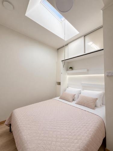 a bedroom with a large white bed with two pillows at Guest House Klevu 17 in Palanga