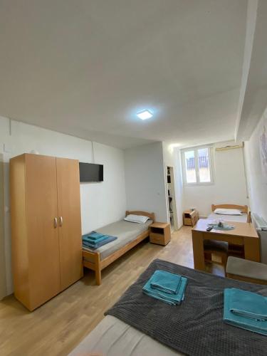 a room with a bed and a desk and a room with a bed at Hostel JAPI in Aleksinac