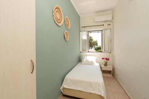 a small bedroom with a bed and a window at Tsanta house in Agios Gordios