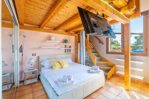 a small bedroom with a bed and a staircase at Pathos Retreat Pool and Garden in Syracuse