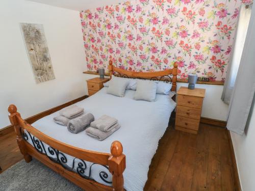 a bedroom with a wooden bed with towels on it at Tor Cefn in Kidwelly