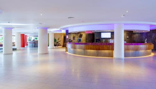 a lobby of a hotel with columns and a bar at SOL by Meliá Lanzarote All Inclusive in Puerto del Carmen