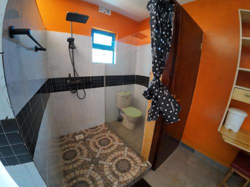 a small bathroom with a shower and a toilet at jc iten in Iten