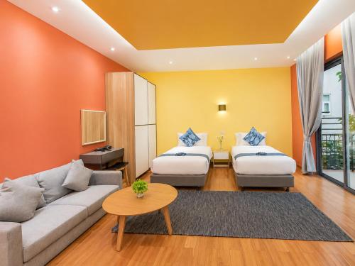 a living room with two beds and a couch at Teetara Villa Patong in Patong Beach
