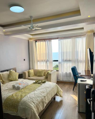 a bedroom with a bed and a couch and a desk at Sky Beach Resort in Kisumu