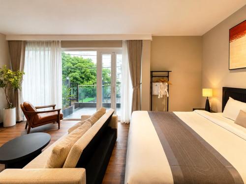 a hotel room with a large bed and a balcony at Amana Boutique Riverside - An Khanh in Ho Chi Minh City