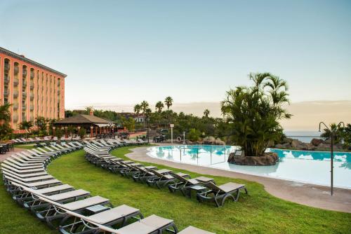 a resort with a pool and lounge chairs at Hotel Las Águilas Tenerife, Affiliated by Meliá in Puerto de la Cruz