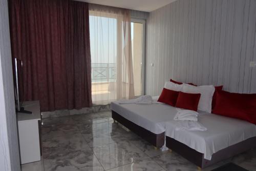a bedroom with two beds and a large window at Golden Sea View Penthouse in Pomorie