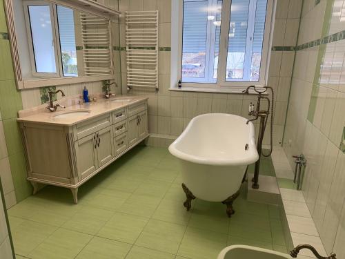 a bathroom with a large bath tub and a sink at Оксамитове ретро in Ternopil