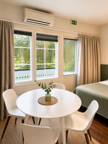 a room with a table and chairs and a bed at Aldeia Bianca Lake Resort & Italian Restaurant in Kerimäki