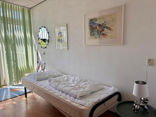 a bedroom with a bed and a table and a window at De Strandloper in Julianadorp