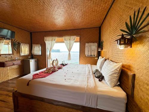 a bedroom with a large bed with a window at Phupai Lake Resort in Ban Wang Khun Knachen