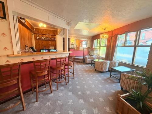 a bar in a restaurant with chairs and tables at The Columbia Hotel in Wellingborough