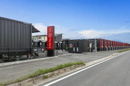a row of train cars parked on the side of a road at HOTEL R9 The Yard Kurate in Nakama