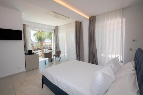 a bedroom with a white bed and a large window at Novaeos Sicily in Terrasini