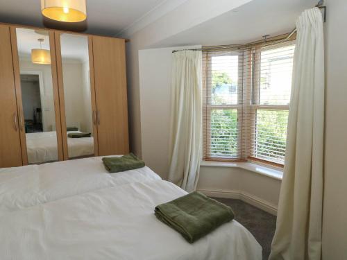 a bedroom with two white beds and a window at Flat 1 in Newton Abbot