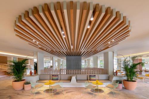 a lobby with tables and a large ceiling at SOL by Meliá Arona Tenerife in Los Cristianos