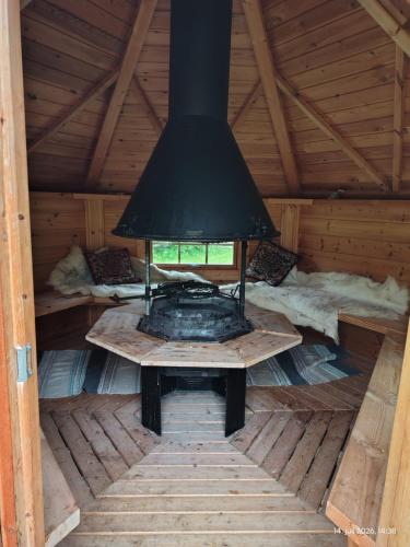 a fireplace in the inside of a wooden cabin at Reisa River Lodge in Potka