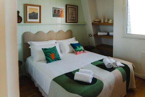 a bedroom with a large bed with towels on it at APPARTEMENT PISCINE TERRASSE 1 MIN PLAGE et GOLF in Bidart