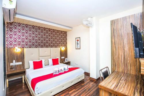 a hotel room with a large bed and a flat screen tv at Hotel O TAJ STARS in Zirakpur