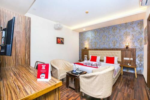 a hotel room with a bed and a table and chairs at Hotel O TAJ STARS in Zirakpur