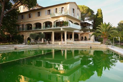 a house with a pool of water in front of it at La Posta Hotel & Thermal Spa - Adults Only in Bagno Vignoni
