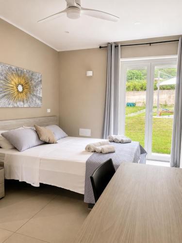 a bedroom with two beds and a table and a window at SottoSopra Tropea in Tropea
