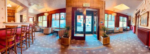 a restaurant with a bar and some chairs and tables at The Columbia Hotel in Wellingborough