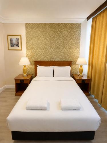 a bedroom with a large white bed with two lamps at The Malik - An Art Deco Hotel in Birmingham