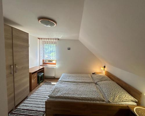 an attic bedroom with a bed and a window at Chata Biely Potok in Oravský Biely Potok