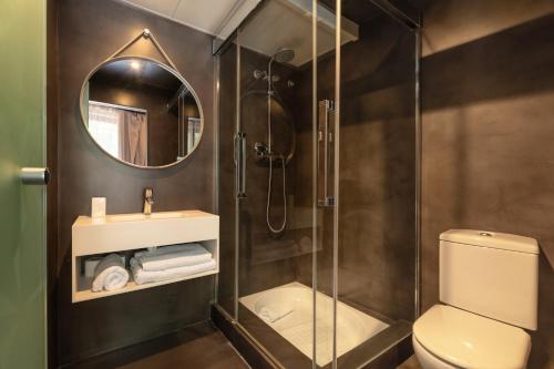 a bathroom with a shower and a toilet and a mirror at Aspasios Born in Barcelona