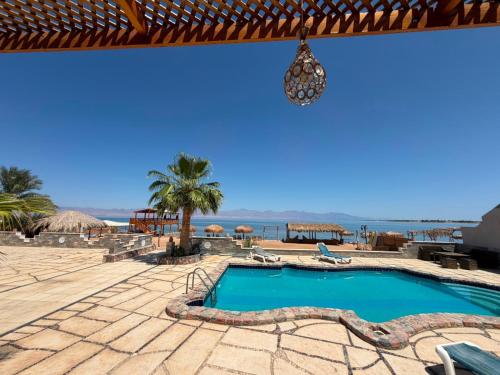 a swimming pool with a view of the ocean at Bonanza beach camp in Nuweiba