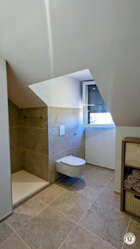 a bathroom with a toilet in the middle of a room at Le Petit Vigneron in Nuits-Saint-Georges