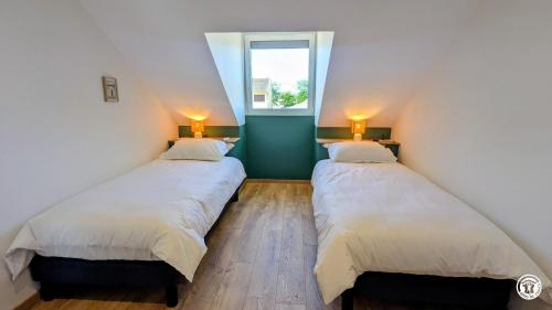 two beds in a room with a window at Le Petit Vigneron in Nuits-Saint-Georges