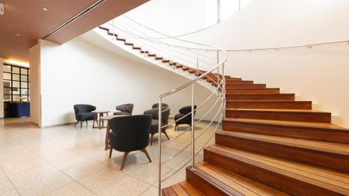 a staircase in a building with chairs and a table at ホテルドゥアッシュ in Kushiro