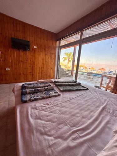 a bedroom with a bed with a view of the ocean at Bonanza beach camp in Nuweiba