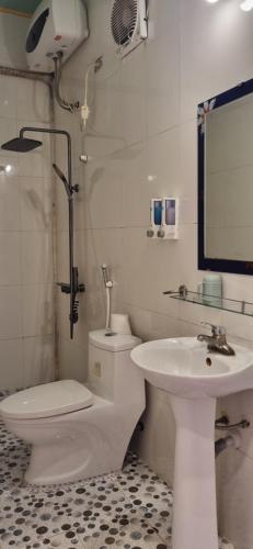 a white bathroom with a toilet and a sink at Tam Coc Family Hotel in Ninh Binh