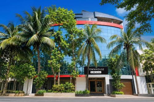 a building with palm trees in front of it at Townhouse Deshapriya Park Kolkata Formerly DK Inn in Kolkata