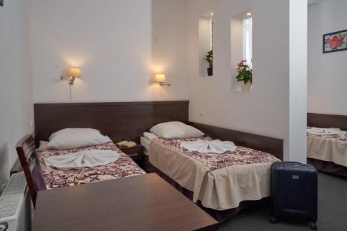 a hotel room with two beds and a table at Hostel Evotel in Zielonka