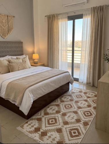 a bedroom with a large bed and a large window at StepInn in El Alamein