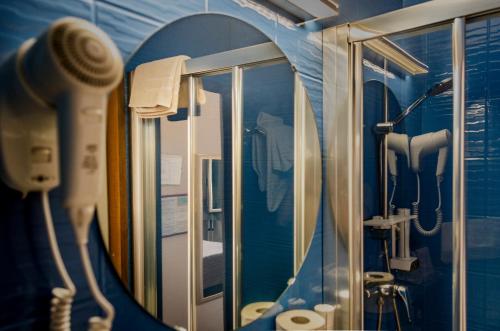 a bathroom with a mirror and a blue wall at Hotel Eden in Turin