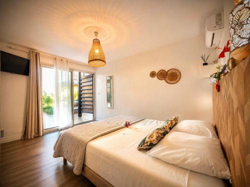 a bedroom with a bed and a large window at Le Vacoa in La Saline les Bains