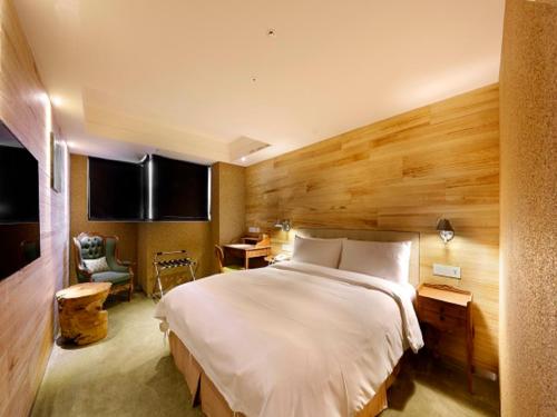 a bedroom with a large bed and a desk at Inhouse Hotel Taichung in Taichung