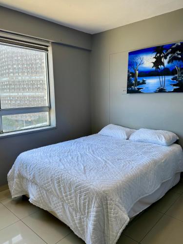a bedroom with a bed and a painting on the wall at Afsaal 612 in Amanzimtoti