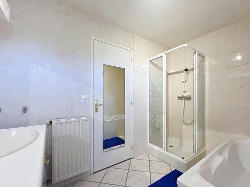 a white bathroom with a shower and a tub at Le Manoir du Butel in Saint-Amand