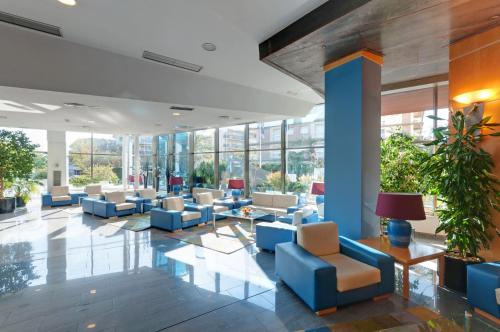 a lobby with couches and chairs in a building at SOL by Meliá Port Cambrils in Cambrils