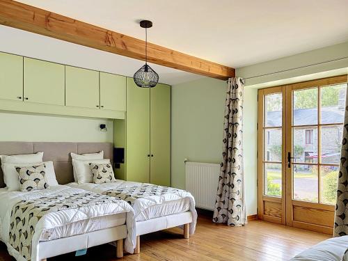 a bedroom with two beds and a window at Le Manoir du Butel in Saint-Amand
